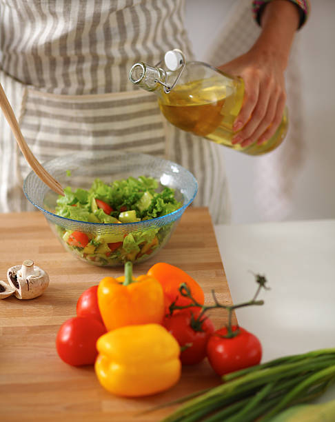 istock Smiling young woman  mixing fresh salad 538447019