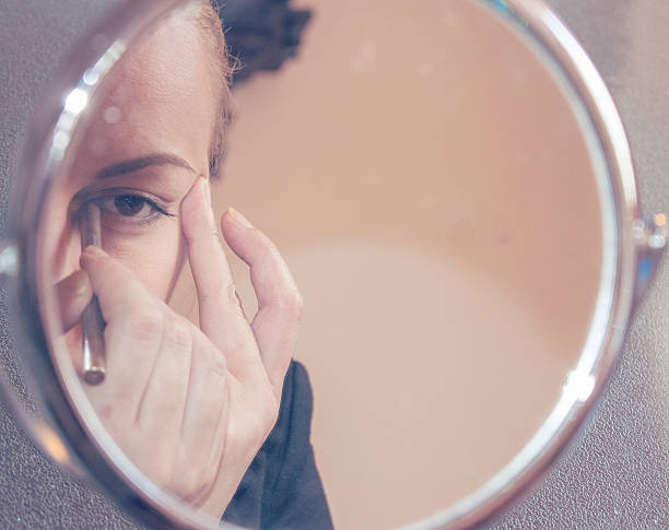 istock Applying makeup in front of the miror 538449074