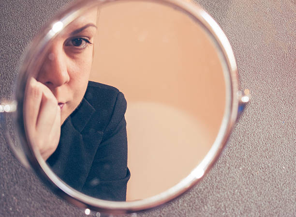 istock Blond woman applying make up in mirror 538451532
