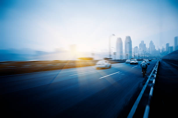istock motion traffic on highway wity city background 538454204