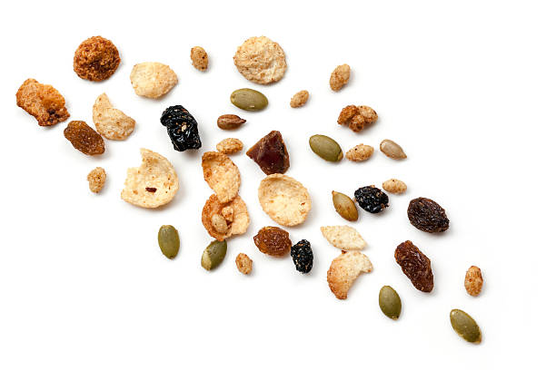 Granola Scattered over White Top View Granola or muesli scattered over white.  Top view. dried fruit on white stock pictures, royalty-free photos & images