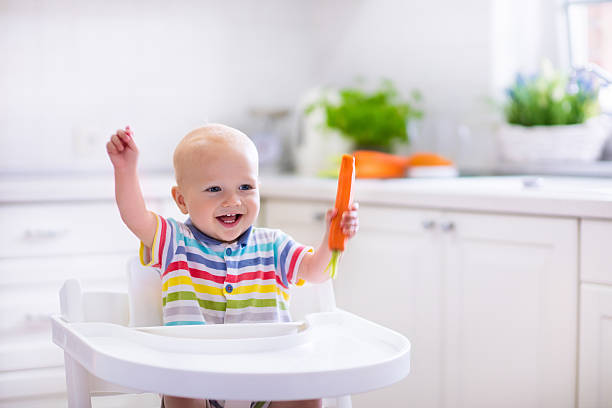 funny little baby comer de zanahoria - baby carrot fotografías e imágenes de stock