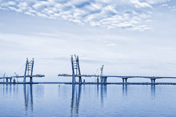 Landscape with bridge construction Monochrome toned landscape with clouds, sea and bridge construction bridge crossing cloud built structure stock pictures, royalty-free photos & images