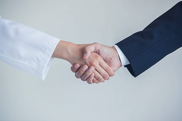 istock Doctor and businessman shaking hands 538465194