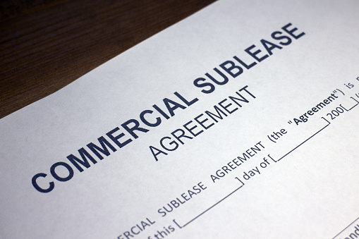 Someone filling out Commercial Sublease Agreement.