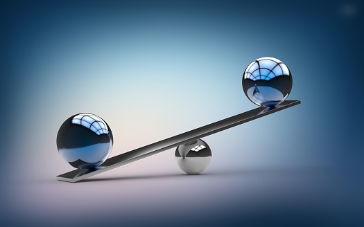 Metallic Blue Orbs Balancing on Small Silver Ball and Metal Beam. Reflections inside balance balls on metal balance beam. Blue, pink color gradient background. Copy space. Scales concept. 