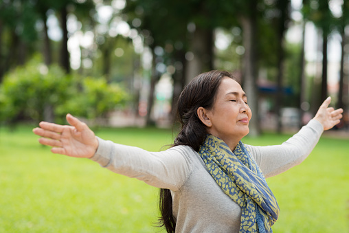 Vietnamese woman breathing fresh air in park