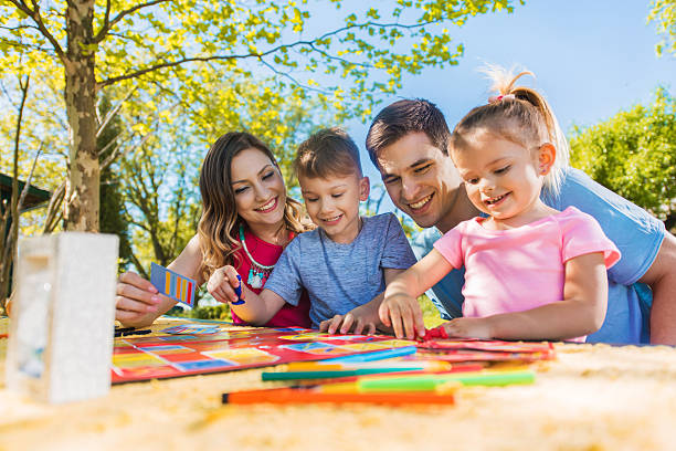 Happy Family Spending A Day Outdoors And Playing Board Game Stock Photo - Download Image Now - iStock