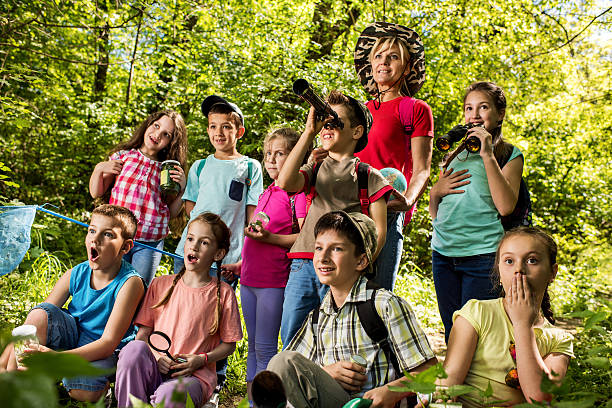 istock Smiling teacher and group of small explorers discovering the nature. 538475940