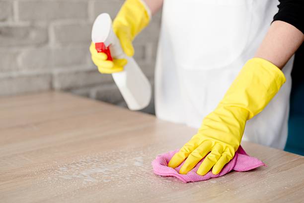 istock Woman in yellow rubber gloves cleaning table 538477776