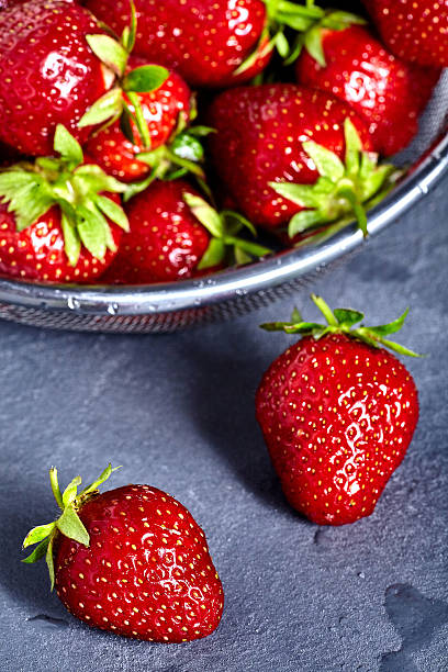 istock Washed strawberries in sieve on stone background 538479906