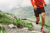 Man trail running on a path in the mountain