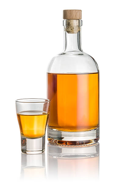 istock Bottle and shot glass filled with amber liquid 538482379