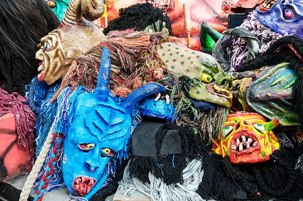 A composition of carnival masks. They were filed on a carriage and lie wildly in a mess.