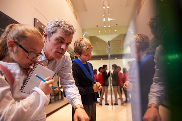 istock Teacher And Pupils Looking At Artifacts On Display In Museum 538483294