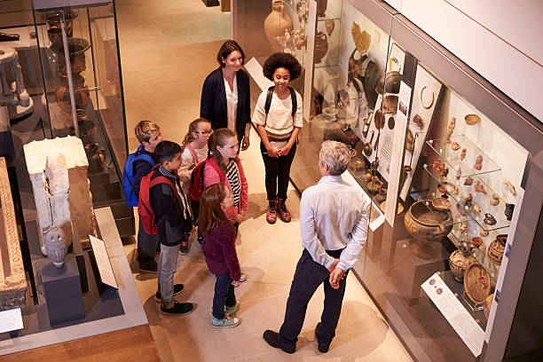 Students Looking At Artifacts In Case On Trip To Museum Students Looking At Artifacts In Case On Trip To Museum antiquities photos stock pictures, royalty-free photos & images