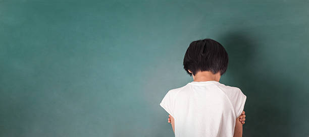 asian girl standing in front of chalk board stock photo