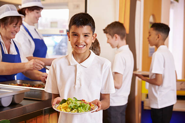 hispana niño en edad escolar es una placa de los alimentos en la escuela de servicio de comidas - niño pre escolar fotografías e imágenes de stock