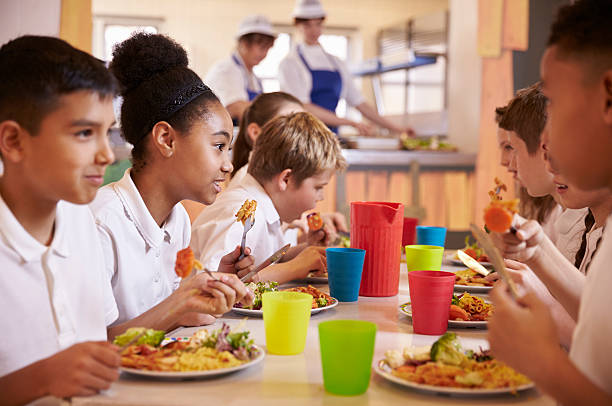 escuela primaria los niños disfrutan del almuerzo en la escuela de servicio de comidas, acercamiento - comedor fotografías e imágenes de stock