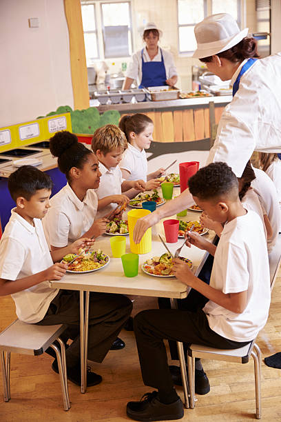 istock Primary school kids eat lunch in school cafeteria, vertical 538486566