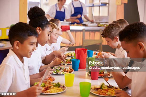 Grundschule Kinder Isst An Einem Tisch In Der Cafeteria Der Schule Stockfoto und mehr Bilder von Kantine