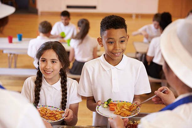 istock Over shoulder view of kids being served in school cafeteria 538486624