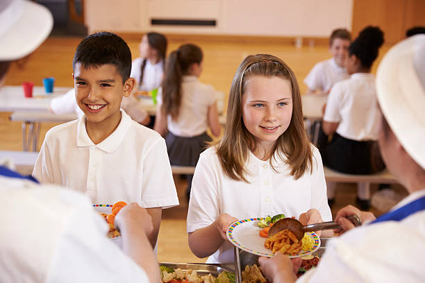 istock Over shoulder view of kids being served in school cafeteria 538486654