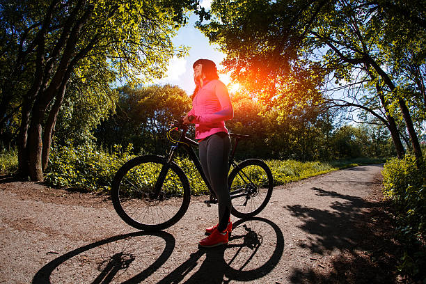 istock cyclist woman riding a bicycle in park 538487334