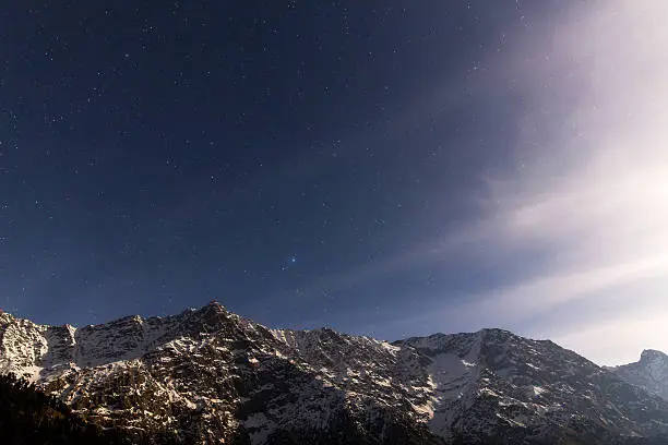 Dhauladhar ranges in Himalayas. Under the starry sky with moonlit mountains. Photo captured from Triund while I camped at this beautiful hill after trekking for 9kms.