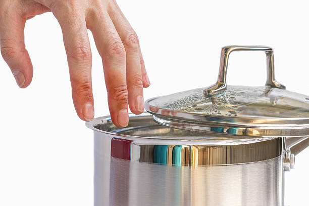 Hand with injuries above boiling water in the pot stock photo