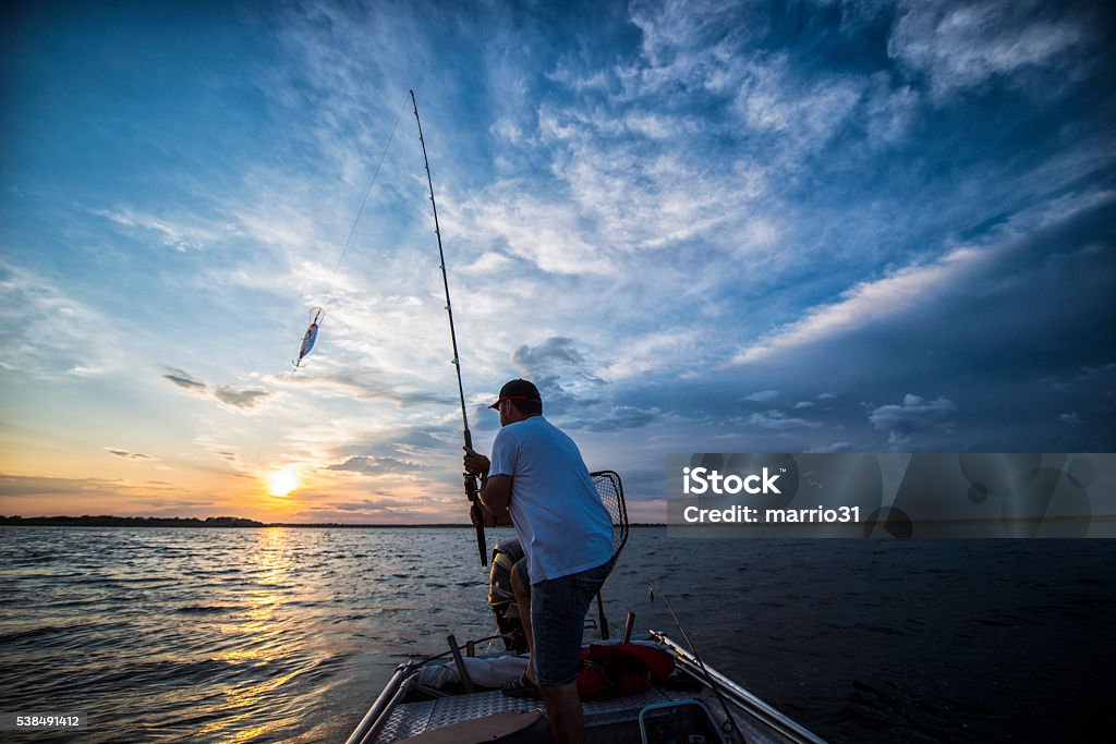 Sunset On The Lake fisherman on the boat Fishing Stock Photo