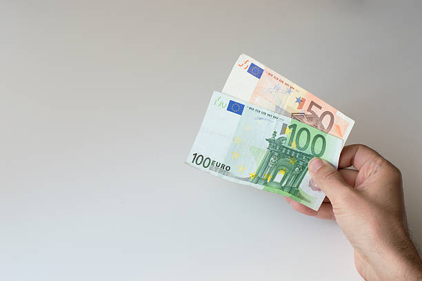 Man holding hundred and fifty Euro banknote in his hands stock photo