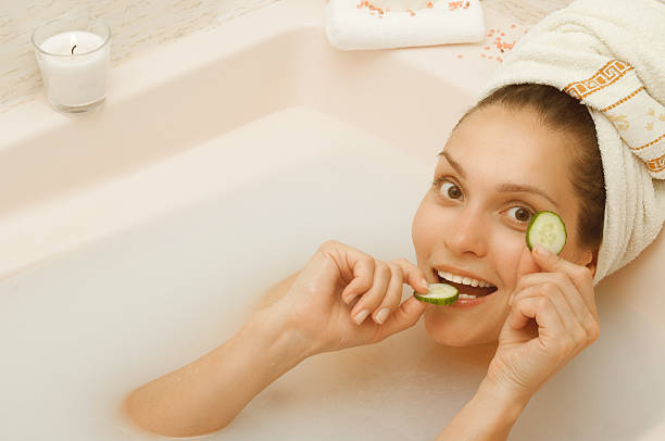 istock girl in bath breast biting cucumber 538493762