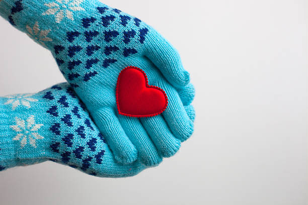 cuore rosso nelle mani in guanti caldi per san valentino - glove winter wool touching foto e immagini stock