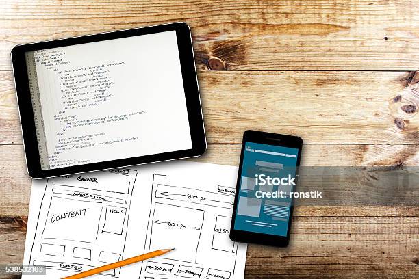 Website Wireframe Sketch And Programming Code On Digital Tablet Stock Photo - Download Image Now