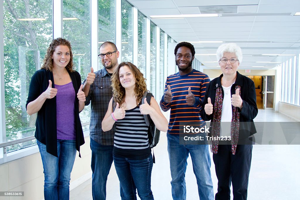 Four excited students with professor Four excited University students with professor 2015 Stock Photo