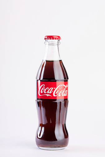 Penza, Russia - February 17, 2015: Coca-Cola Classic in a glass bottle with reflections on light Background