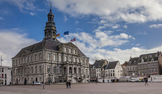 Maastricht, The Netherlands - Januari 29, 2015: The central market  square in Maastricht is dominated by the Town Hall, which was built in the 17th century by Pieter Post and is considered one of the highlights of Dutch Baroque architecture. Historical houses form the border of the square