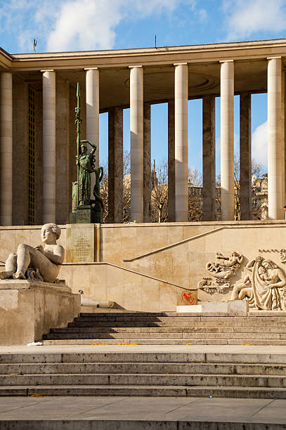 Paris, France - October 2019: The Trocadero complex, built for the 1937 Universal Exhibition in Paris, includes gardens, museums such as the Musee de l'Homme, and an expansive plaza which is a popular gathering place offering the quintessential view of the Eiffel Tower across the Seine River. Several works of art can be found in the plaza including this towering bronze statue of Hercules and the Bull by Albert Pommier.