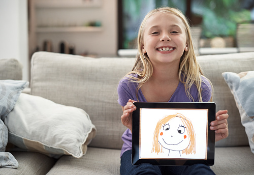 Portrait of a young girl using a digital tablet at home