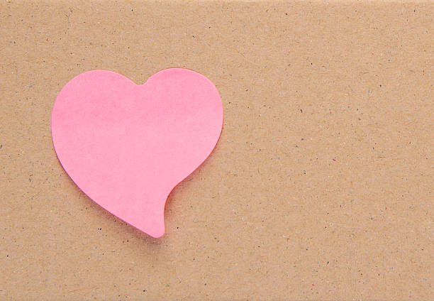 istock Pink label paper heart on Brown cardboard. 538566500
