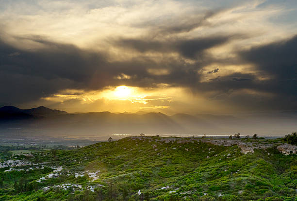 istock Sunset Shining Through Clouds Over Green Mountain Terrain and Gazebo 538566634