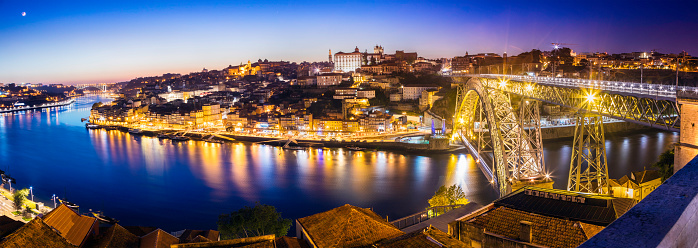 The Ribeira esplanada with tourist taking boat rides along the river Douro. This is a popular tourist destination along the riverside and the Dom Luid I bridge a monument now declared a UNESCO World Heritage site. Porto is the second largest city of Portugal situated in the north of Portugal. 