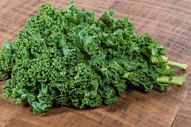istock Curly kale leaves on wooden table 538567553