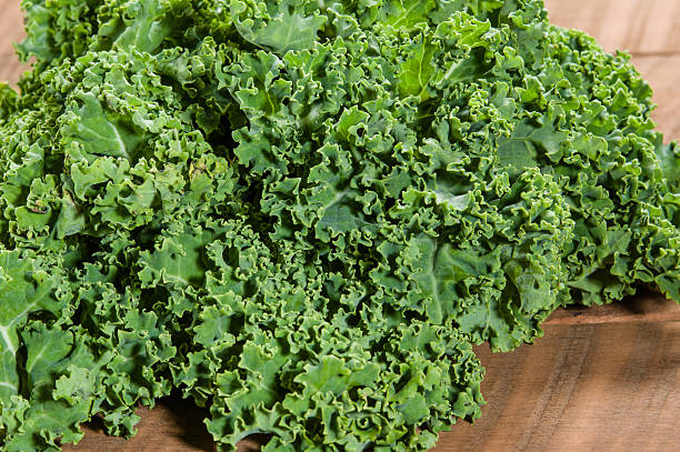 istock Curly kale leaves on wooden table 538567585