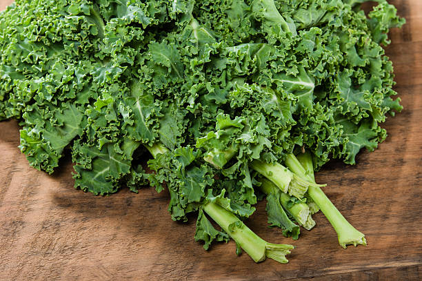 istock Curly kale leaves on wooden table 538567589