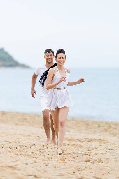 istock Barefoot couple on sand seashore in cloudy day 538568694