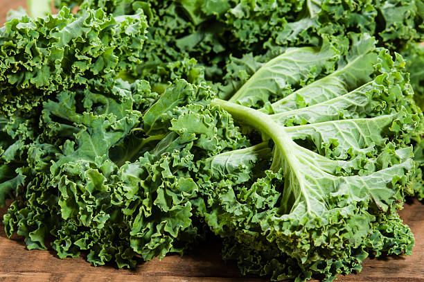 istock Curly kale leaves on wooden table 538568715