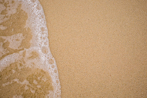 istock Closeup of sand and small wave 538569919