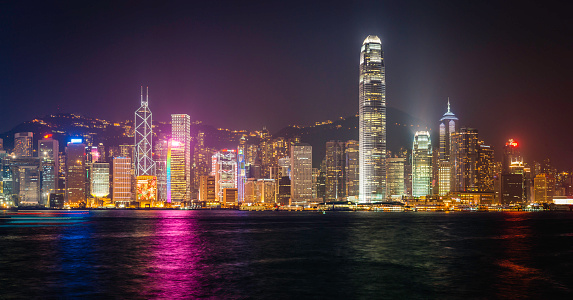 The vibrant lights of Hong Kong Island, highrise apartment buildings and neon skyscrapers looking over Victoria Harbour in this futuristic panoramic night vista of modern China. ProPhoto RGB profile for maximum color fidelity and gamut.
